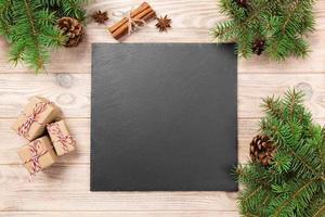 Slate blackboard on wooden table with christmas decoration. black slate stone on wooden background. copy space. New Year concept photo