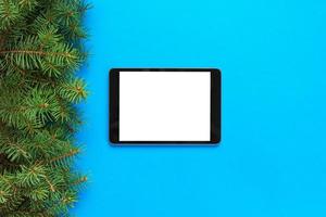 blank screen tablet on blue background, christmas time top view photo
