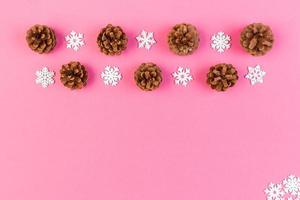 Top view of New Year ornament made of white snowflakes and pine cones on colorful background. Winter holiday concept with empty space for your design photo