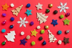 Top view of holiday decorations and toys on red background. Christmas ornament concept photo
