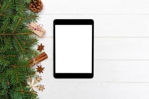 Digital tablet mock up with rustic Christmas wooden background decorations for app presentation. top view with copy space photo