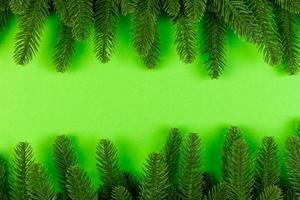 Top view of frame made of fir tree on colorful background with copy space. Merry Christmas concept photo