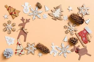 vista superior de los juguetes y decoraciones de año nuevo sobre fondo naranja. concepto de tiempo de navidad con espacio vacío para su diseño foto