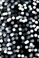 Unfocused abstract white bokeh on black background. defocused and blurred many round light photo