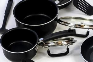 juego de utensilios de cocina, juego de cena de acero aislado en fondo blanco, juego de utensilios de cocina de metal negro foto