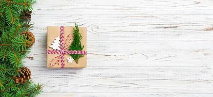 caja de regalo de navidad envuelta en papel reciclado, con lazo de cinta, con cinta sobre fondo rústico. concepto de banner de vacaciones foto