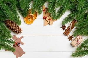 Top view of fir tree branches and festive decorative toys on wooden background. New Year time concept with empty space for your design photo