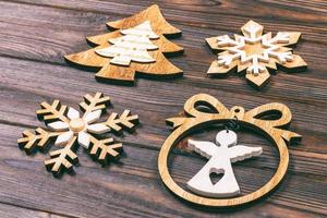 Christmas snowflakes, Christmas tree and angel in a frame on a wooden background. New Year wooden decorations. Toned photo