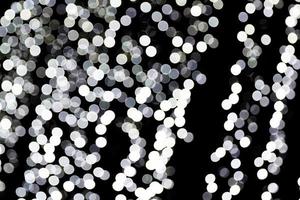 Unfocused abstract white bokeh on black background. defocused and blurred many round light photo