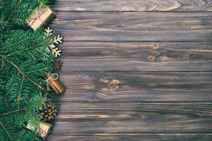 Christmas vintage, toned background with fir tree and gift box on wooden table. Top view with copy space for your design photo