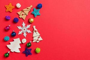 Top view of holiday decorations and toys on red background. Christmas ornament concept with empty space for your design photo