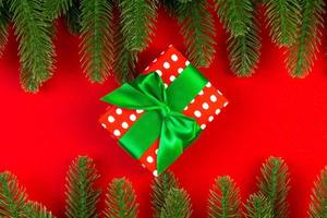 Top view of gift box and fir tree branches on colorful background. Merry Christmas concept with empty space for your design photo