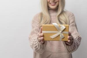 retrato, de, caucásico, mujer joven, llevando, suéter, tenencia, regalos, caja, encima, fondo blanco foto