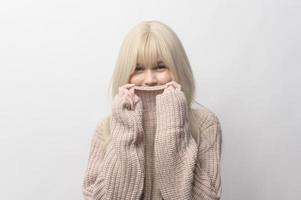 Portrait of Caucasian young woman wearing sweater over white background photo