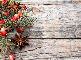 Pomegranate spruce branches star anise nuts, cinnamon and winter spices on wooden background, Rustic style Copy space photo