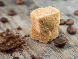 azúcar de caña marrón con granos de café sobre fondo de madera rústica