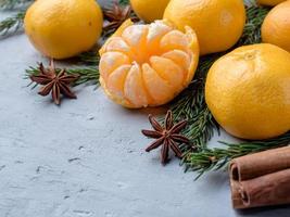 Fresh tangerines with branches of Christmas tree, star anise cinnamon on gray concrete background Copy space photo