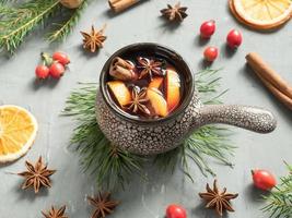 Christmas mulled wine with cinnamon, orange and anise in a ceramic bucket photo