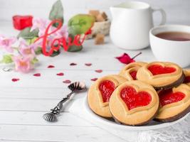 galletas caseras con mermelada roja corazón taza de té del día de san valentín foto