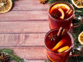 Christmas mulled wine with orange and spices on wooden background. Copy space photo