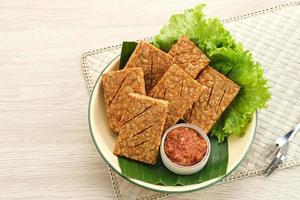 Tempeh, Tempe Goreng or Fried tempeh is Indonesia traditional food, made from fermented soybean seeds. Served with sambal. photo