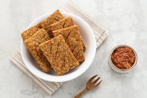 Tempeh, Tempe Goreng or Fried tempeh is Indonesia traditional food, made from fermented soybean seeds. Served with sambal. photo