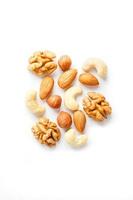 Isolated nuts pattern background. Walnut, cashew, almond and hazelnut on white background. View from above. photo