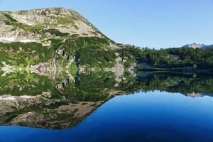 reflection of the mountain on water, mirror image of mountains in water photo