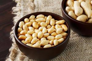 Peanuts in the shell and peeled closeup in a cup photo