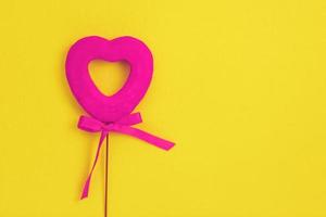 Pink heart on a yellow background. Bow.Love photo