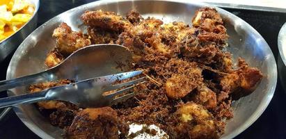 Ayam goreng rempah or traditional Javanese fried chicken, cooked on frying pan photo