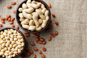 Peanuts in the shell and peeled closeup in a cup photo