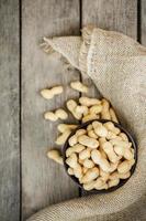 Peanuts in the shell, in a wooden cup on the table. photo