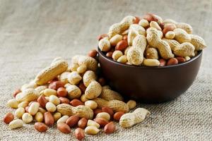 Peanuts in the shell and peeled closeup in a cup photo