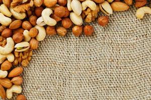 Mix of nuts lying on a background of brown cloth burlap. photo