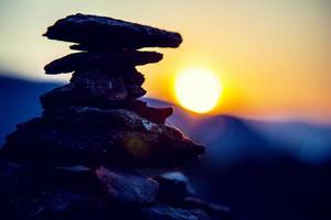 equilibrio de piedras de spa, fondo colorido del cielo de verano, silueta de guijarros y mariposas apilados, naturaleza hermosa, puesta de sol tranquila en la playa, imagen conceptual de vida estable foto