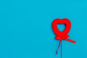 corazón rojo con un lazo sobre un fondo azul. amor. día de San Valentín foto