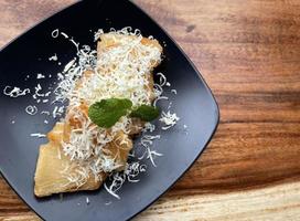 fried cassava with topping grated cheese on top photo