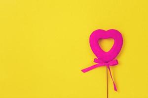 Pink heart on a yellow background. Bow.Love photo