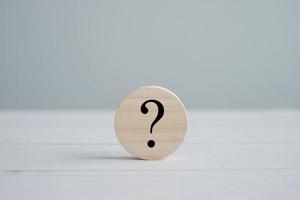 Question mark symbol on wooden circle. Ask, FAQ, Advice, Support, Problem and solution concept. photo