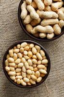 Peanuts in the shell and peeled closeup in a cup photo