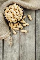 Peanuts in the shell, in a wooden cup on the table. photo