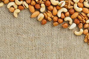 Mix of nuts lying on a background of brown cloth burlap. photo