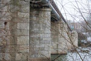 stone bridge over the river in winter photo