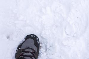 foot with hiking boot on snow photo