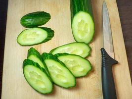 A smooth, medium-sized cucumber cut into slices. Cucumber on a cutting board. Vegetable isolate. Fresh ripe vegetable photo