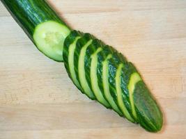 A smooth, medium-sized cucumber cut into slices. Cucumber on a cutting board. Vegetable isolate. Fresh ripe vegetable photo