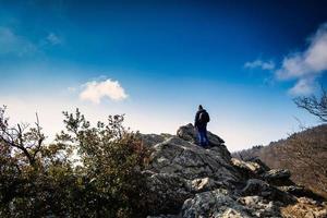 un hombre observa el horizonte desde lo alto de una colina mirando hacia el infinito foto