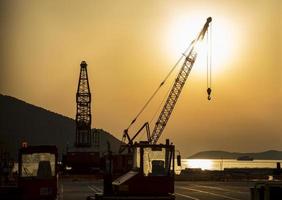 Silhouette of Harbor crane during sunset in Greece. photo