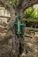 bomba de agua de mano antigua en un pozo en el jardín, riego y ahorro de agua en austria. foto